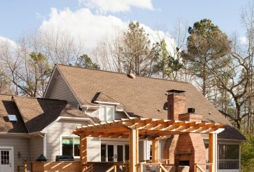 outdoor fireplace area in a floating deck with a pergola