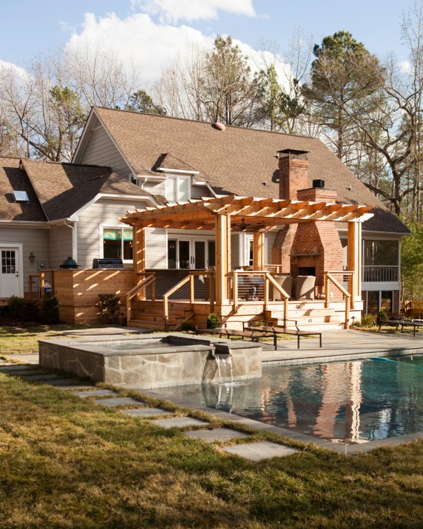 outdoor fireplace area in a floating deck with a pergola
