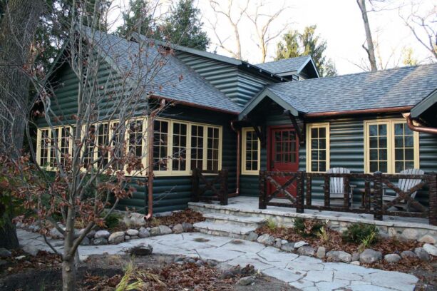 concrete porch in a green and yellow log cabin exterior