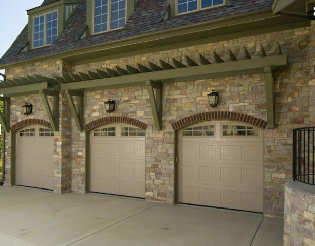 olive green painted pergola over beige-colored garage doors