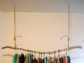 rustic styled hanging clothes rack from the ceiling made of a solid branch