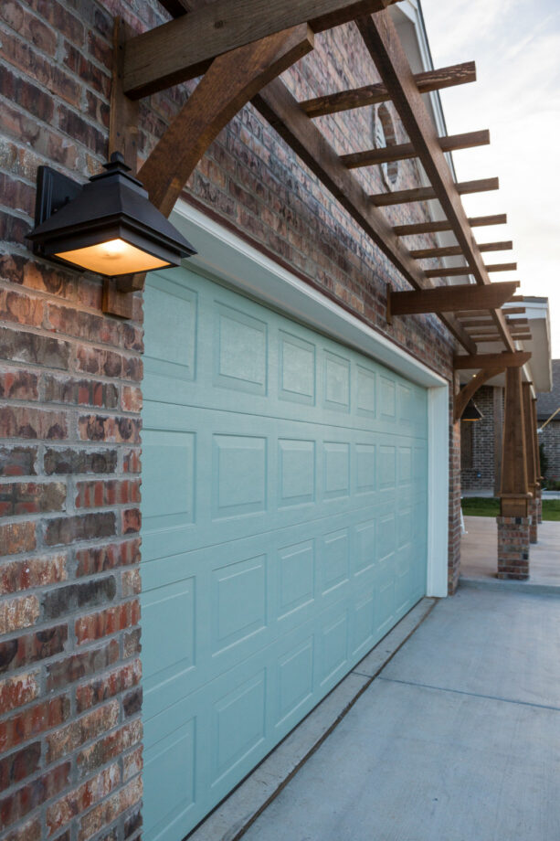 simple pergola over mint green garage doors