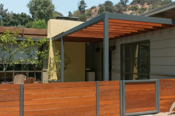 a low mid-century modern fence made of redwood lumber and steel posts
