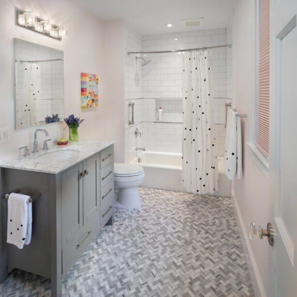 blush pink walls with gray herringbone ceramic bathroom tiles