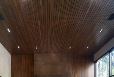 oxidized metal surround fireplace with wood wall and ceiling paneling