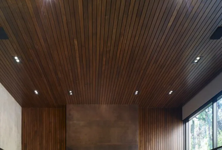 oxidized metal surround fireplace with wood wall and ceiling paneling